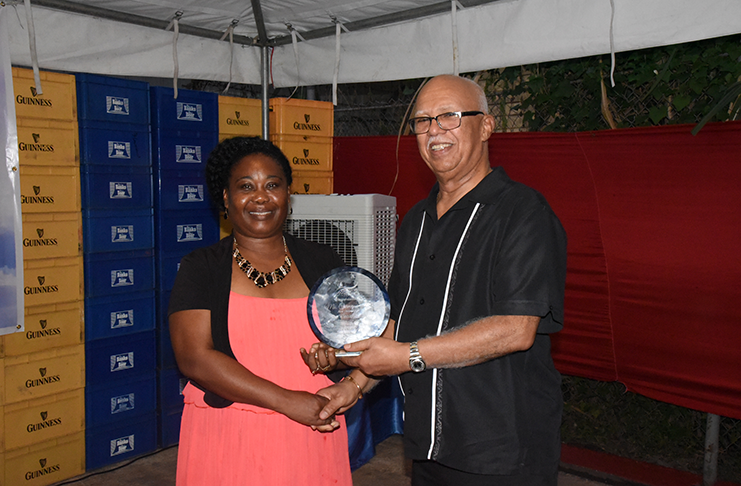 Mrs Carmen Small General Manager of District 10 receives the plaque from Banks DIH Chairman Clifford Reis