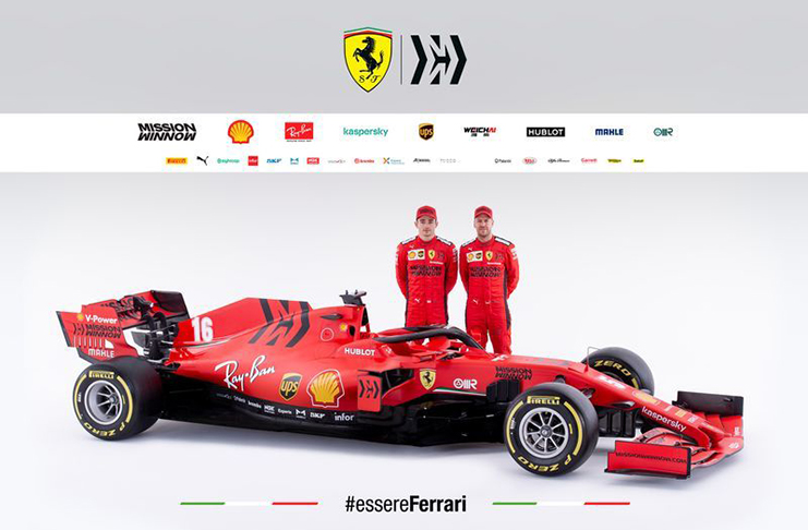 Ferrari's drivers Charles Leclerc and Sebastian Vettel pose next to the new Ferrari Formula One in this handout photo released  Tuesday. Ferrari Press Office/Handout via REUTERS
