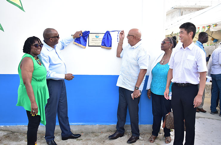 Director General of the Ministry of the Presidency, Joseph Harmon, and GWI's Managing Director, Dr. Richard Van-West Charles unveil the plaque at the facility, as REO of Region Three, Jennifer Ferreira-Dougall, and other officials look on (GWI photo)