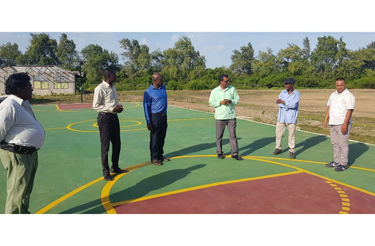 Minister of Public Security, Khemraj Ramjattan standing on the newly-commissioned hard court in the presence of regional officials
