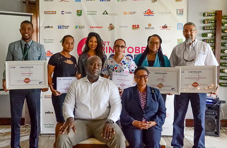 GTT CEO, Justin Need (seated) and Public Health Minister, Volda Lawrence, with representatives from some of the major companies that sponsored Pinktober 2019