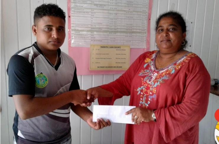 Left, BCB PRO Simon Naidu receives cheque from Berbice manager.