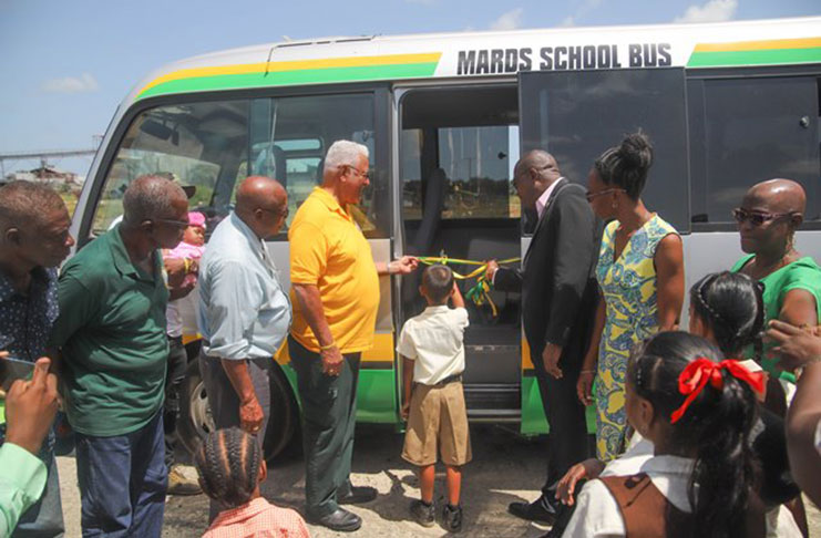 A pupil of the Augsburg Primary School assisted Minister of Agriculture Noel Holder and Public Infrastructure Minister David Patterson with the cutting of the ribbons to officially commission the $7.3M MARDS school bus