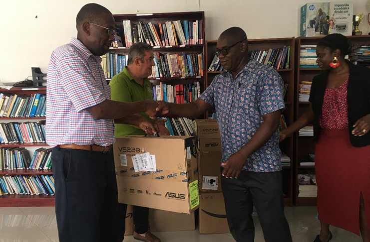 Nations Inc Chief Executive Officer, Dr Dexter Phillips, hands over one of the systems to an official from the Guyana Prison Service