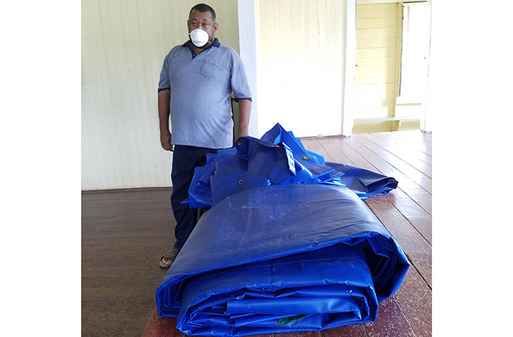 BCB president Hilbert Foster poses with the cricket pitch covers.