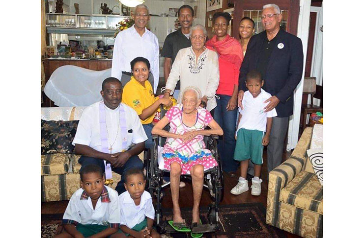 Aunt Ina sits in the company of President David Granger (left standing) and her nephew, Minister of Agriculture, Noel Holder (right standing) along with relatives and friends back in 2016