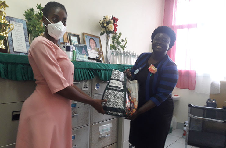 Matron August (right) presenting one of her healthcare providers with a hamper