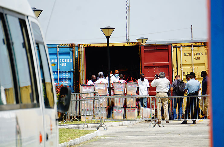 Representatives of the various political parties observing the opening of the containers by GECOM personnel at the ACCC (Elvin Croker Photo)
