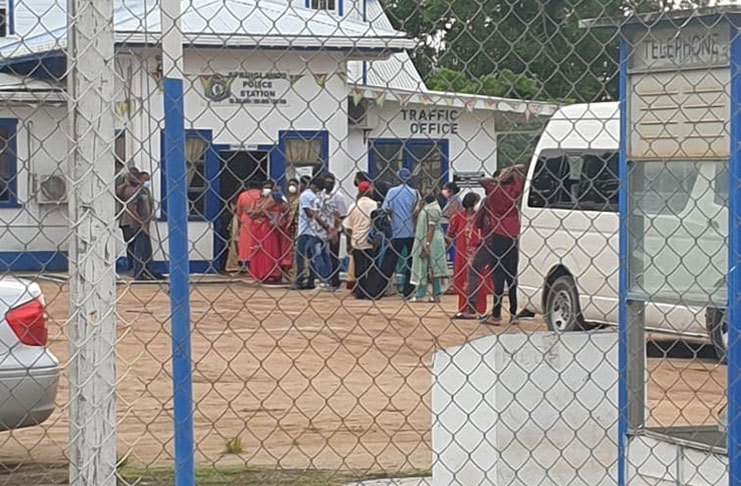 Some of Bisram’s guests awaiting to be processed at the Springlands Police Station on Saturday afternoon