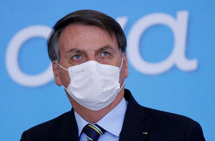 Brazil's President Jair Bolsonaro wearing a protective face mask looks on during an inauguration ceremony of the new Communications Minister Fabio Faria (not pictured) at the Planalto Palace, in Brasilia, Brazil June 17, 2020. REUTERS/Adriano Machado