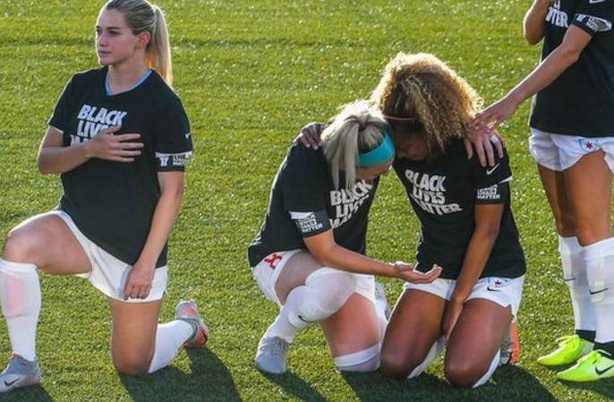 Chicago defender Casey Short (centre right) was embraced by captain Julie Ertz (centre left) as they knelt during the anthem