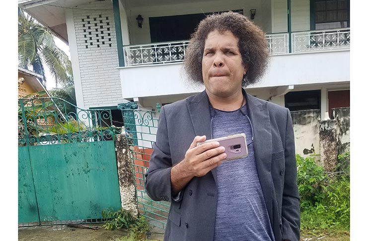 Michael Rodrigues, known as the Guyanese Critic, outside his South Ruimveldt home as persons protested racist remarks he made last Monday (Tamica Garnett photo)