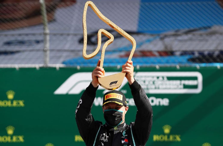 Mercedes' Valtteri Bottas celebrates with the trophy on the podium after winning the race, as F1 resumes following the outbreak of the coronavirus. Photograph: Mark Thompson/Reuters