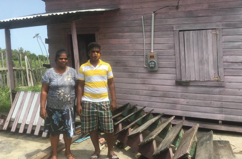 Roopranie Latchminarine and her 16-year-old son Romel Richard stands infront of their house that fell to the ground