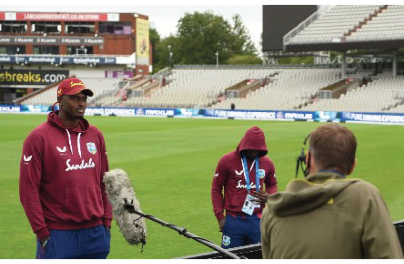 Captain Jason Holder (left) conducts a media interview at Old Trafford using social distancing.