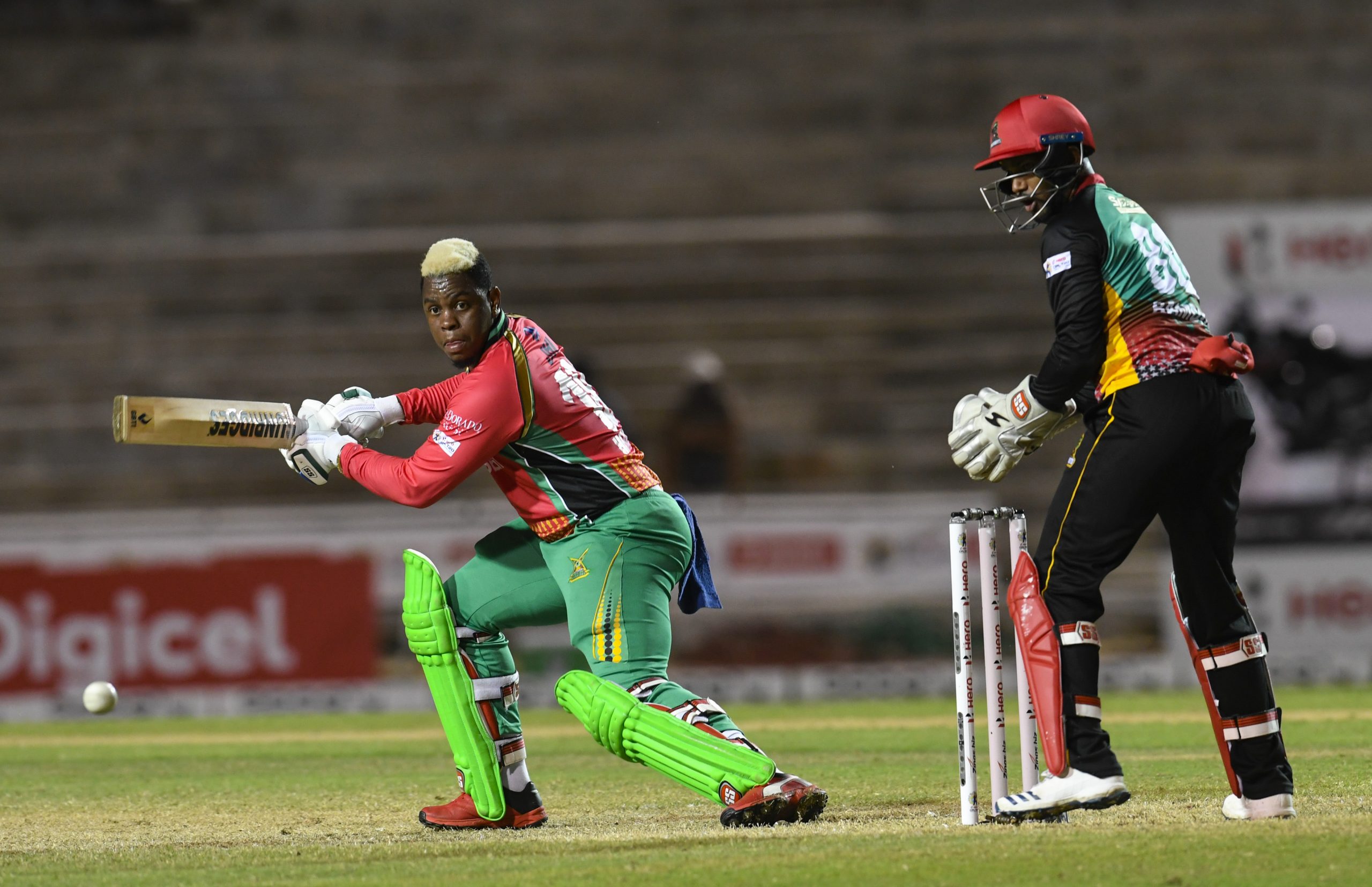 Shimron Hetmyer (L) of Guyana Amazon Warriors plays the cut shot as Denesh Ramdin (R) St Kitts & Nevis Patriots watches on (Photo by Randy Brooks - CPL T20/CPL T20 via Getty Images)