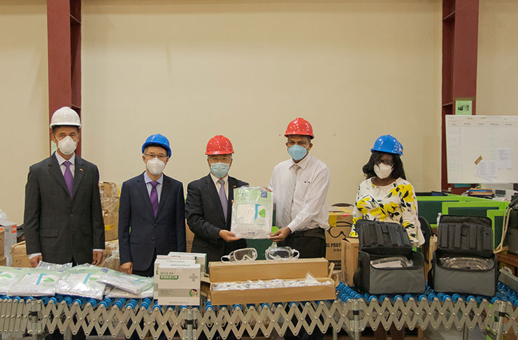 Chinese ambassador to Guyana, Cui Jianchun, hands over items to Minister of Health, Dr. Frank Anthony, in the presence of a representative from the Chinese Embassy in Guyana (DPI photo)