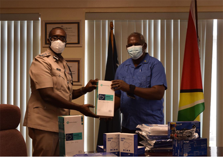 Minister of Home Affairs, Robeson Benn, handing over PPE to the Commissioner of Police (ag) Nigel Hoppie