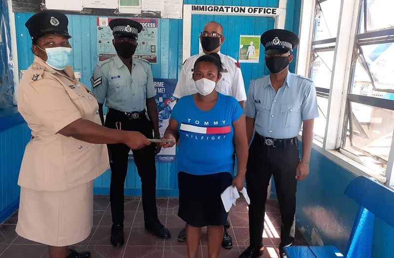 Police from Charity handing over the money to the grandmother of the deceased  