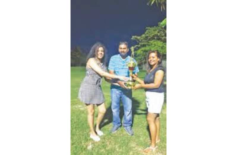  Jayana Butts (right) Parshuram Arjune (center) hand over the winning trophy to Michelle Codrington (left)