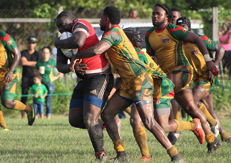 Claudius Butts makes a tackle on his Trinidadian counterpart during a clash last year in Guyana.