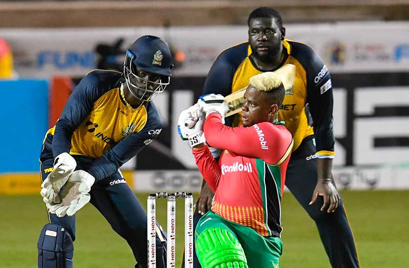 Shimron Hetmyer (C) of Guyana Amazon Warriors hits 6 as Andre Fletcher (L) and Rahkeem Cornwall (R) of St Lucia Zouks watch during the Hero Caribbean Premier League match 24 between St Lucia Zouks and Guyana Amazon Warriors at Brian Lara Cricket Academy on September 2, 2020 in Tarouba, Trinidad And Tobago. (Photo by Randy Brooks - CPL T20/CPL T20 via Getty Images)