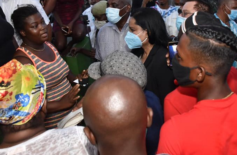 Minister of Home Affairs, Robeson Benn and Minister of Human Services and Social Security, Dr. Vindhya Persaud, interact with a relative of Joel Henry recently