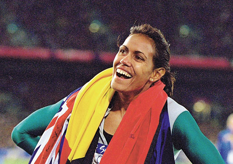 Cathy Freeman celebrates her Sydney Olympic gold medal win with the Aboriginal and Australian flags. (Credit:Nick Wilson/Allsport)