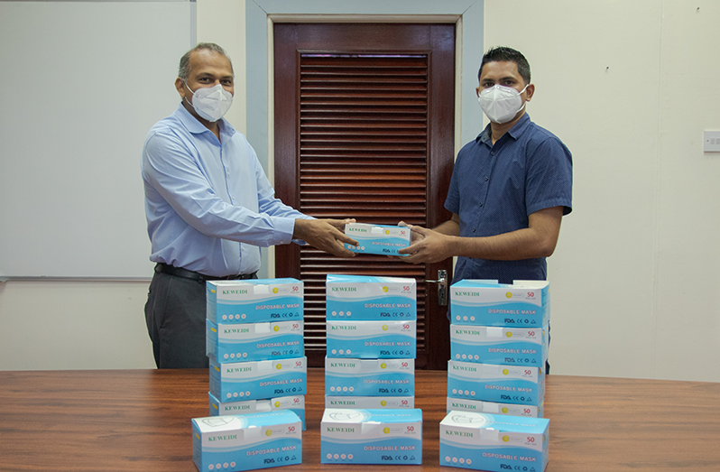 Minister of Health, Dr. Frank Anthony (left), receives equipment from Feyaad Nohar of Leading Technology