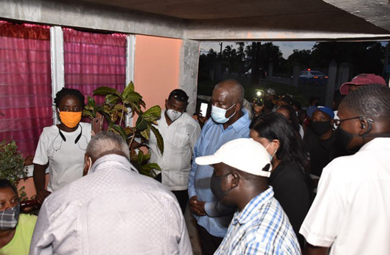 Prime Minister, Brigadier (ret’d) Mark Phillips, along with Ministers Dr. Vindhya Persaud and Robeson Benn, interact with Patricia Henry, mother of Isaiah Henry, who was killed recently along with his cousin