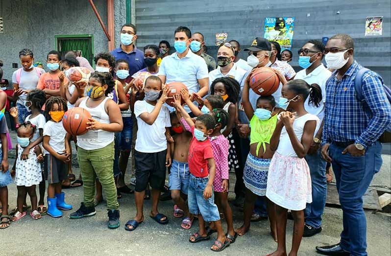 Minister of Sport Charles Ramson Jr and members of the visiting team with youths of the community (Photo: Ministry of Culture, Youth and Sport)