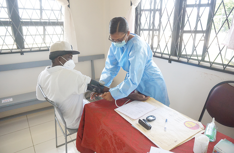 A nurse attached to the Cotton Tree Health Centre in the triage area tending to a patient (Carl Croker photos)