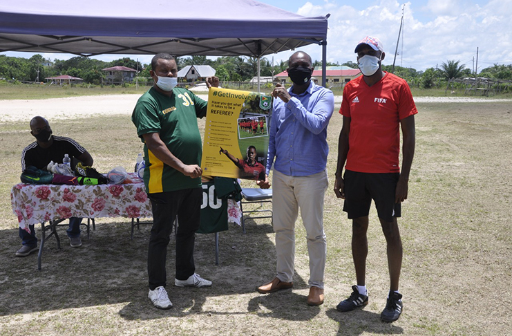 Caption:

 

GFF president Wayne Forde (2nd right) hands over a promotional poster to Coomacka United FC president Renison Rawlins in the presence of Abdullah Hamid.