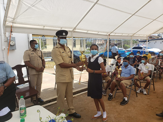 A Springlands Primary School pupil receives a trophy and a medallion from Commander Ramlakhan during the ceremony
