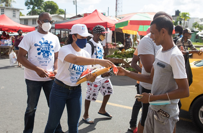 Minister within the Ministry of Housing and Water Susan Rodrigues, sharing masks at La Penitence Market