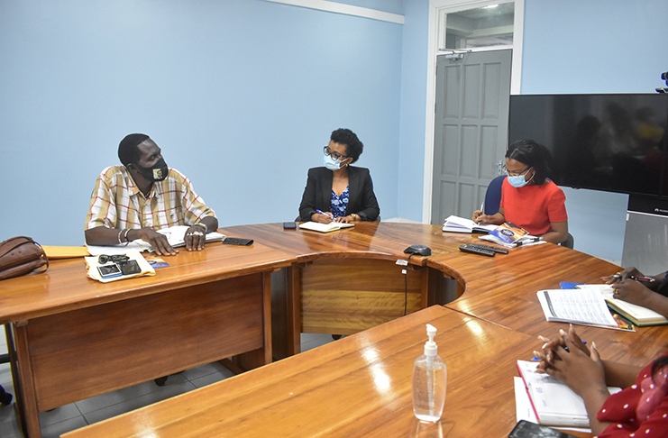 President of the United Minibus Union, Eon Andrews (left) and other union executives met with the Minister of Tourism, Commerce and Industry, Oneidge Walrond, (right) last Tuesday