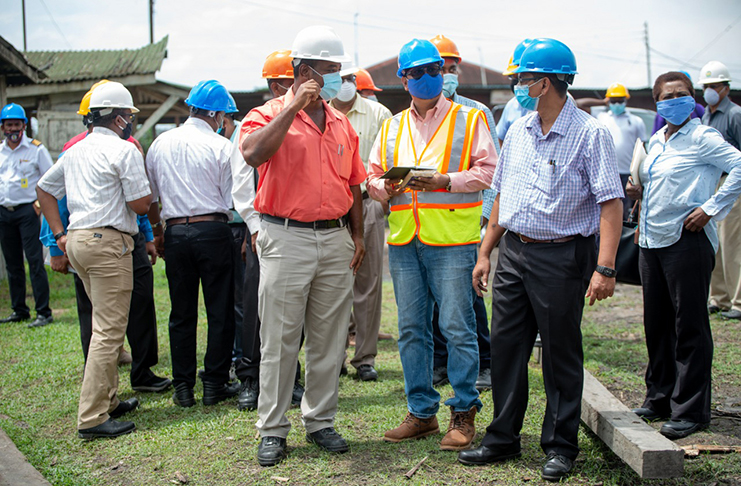 GuySuCo Chief Executive Officer, Sasenarine Singh (in blue mask), interacts with Blairmont estate officials during a visit to the estate on Wednesday (Marceano Narine photo)