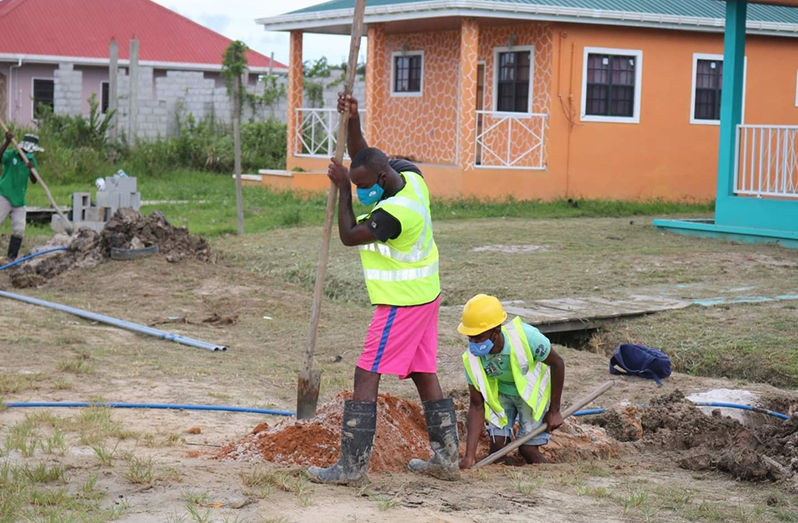 Water flows from a newly-installed individual service connection. In the photo are: Minister within the Ministry of Housing and Water, Susan Rodrigues and GWI's East Bank Demerara Manager, Nishaul Samaroo