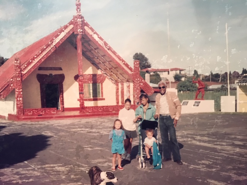 Farrier with four Maori children in front of a Maori church in New Zealand