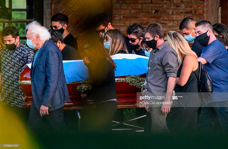 Relatives and friends carry the coffin of Argentine football legend Diego Armando Maradona during his funeral at the Jardin Bella Vista cemetery, in Buenos Aires province, on November 26, 2020. (Photo by Ronaldo Schemidt/AFP)