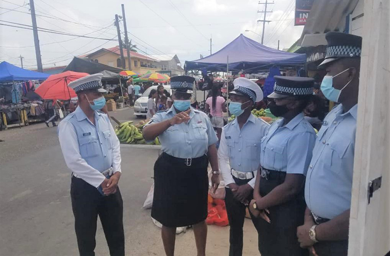 Police ranks at a mobile outpost at the Plaisance Market on the East Coast of Demerara, strategising their operations on Sunday