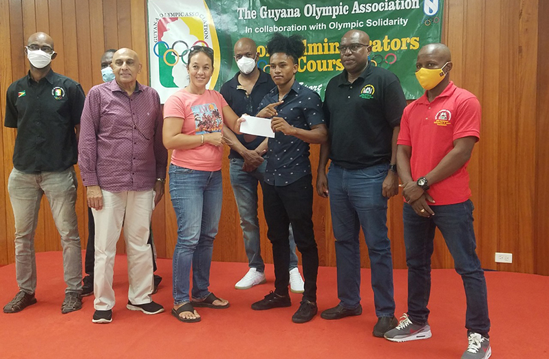 Keevin Allicock (third from right), flanked by GOA and GBA executives, receives his GOA Olympic Solidarity Scholarship from GOA’s Tricia Fiedtkou.