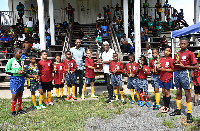 Vurlon Mills Academy captain, Christian Enderson, receives the fourth EBFA
Ralph Green U-11 League champions trophy from Ralph Green