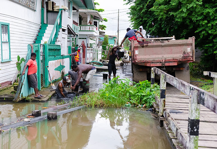 A few of the young men from Albouystown, Georgetown, who were employed by the Ministry of Local Government
and Regional Development, cleaning and desilting a drain in James Street (Delano Williams photo)