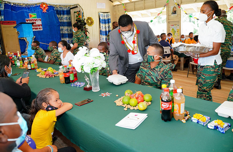 President Irfaan Ali serves a Guyana Defence Force rank who is stationed at Kaikan, Region Seven (Office of the President photo)