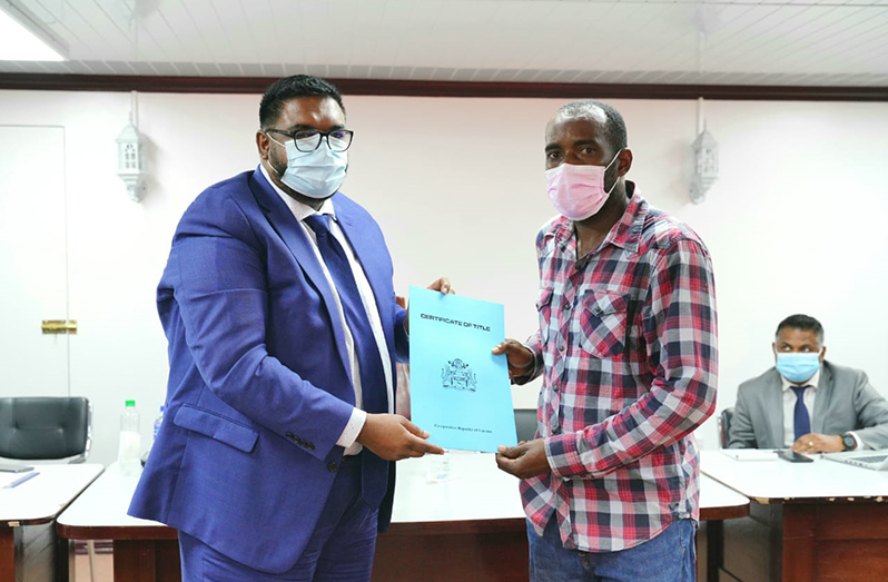 President, Dr Irfaan Ali presents Esaan Garraway with his Certificate of Title during an outreach to Region Two on Wednesday.
Garraway is one of three persons who finally received house lot titles, after waiting for many years