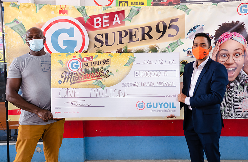 Roy Lennox Marshall (left) receiving the cheque from GUYOIL General Manager, Trevor Bassoo (Delano Williams photo)
