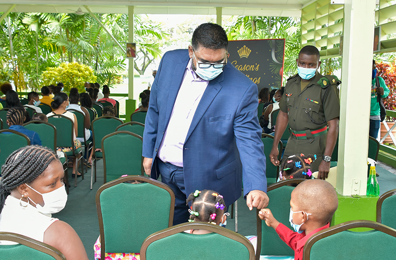 President Dr. Irfaan Ali greets one of the youngsters at Thursday’s party at the State House