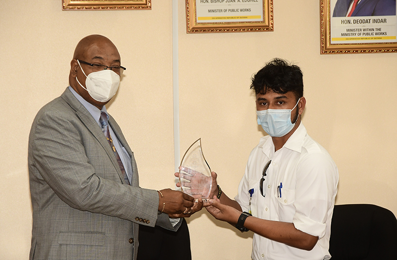 Azam Ally receiving his plaque from Senior Minister of Public Works, Juan Edghill