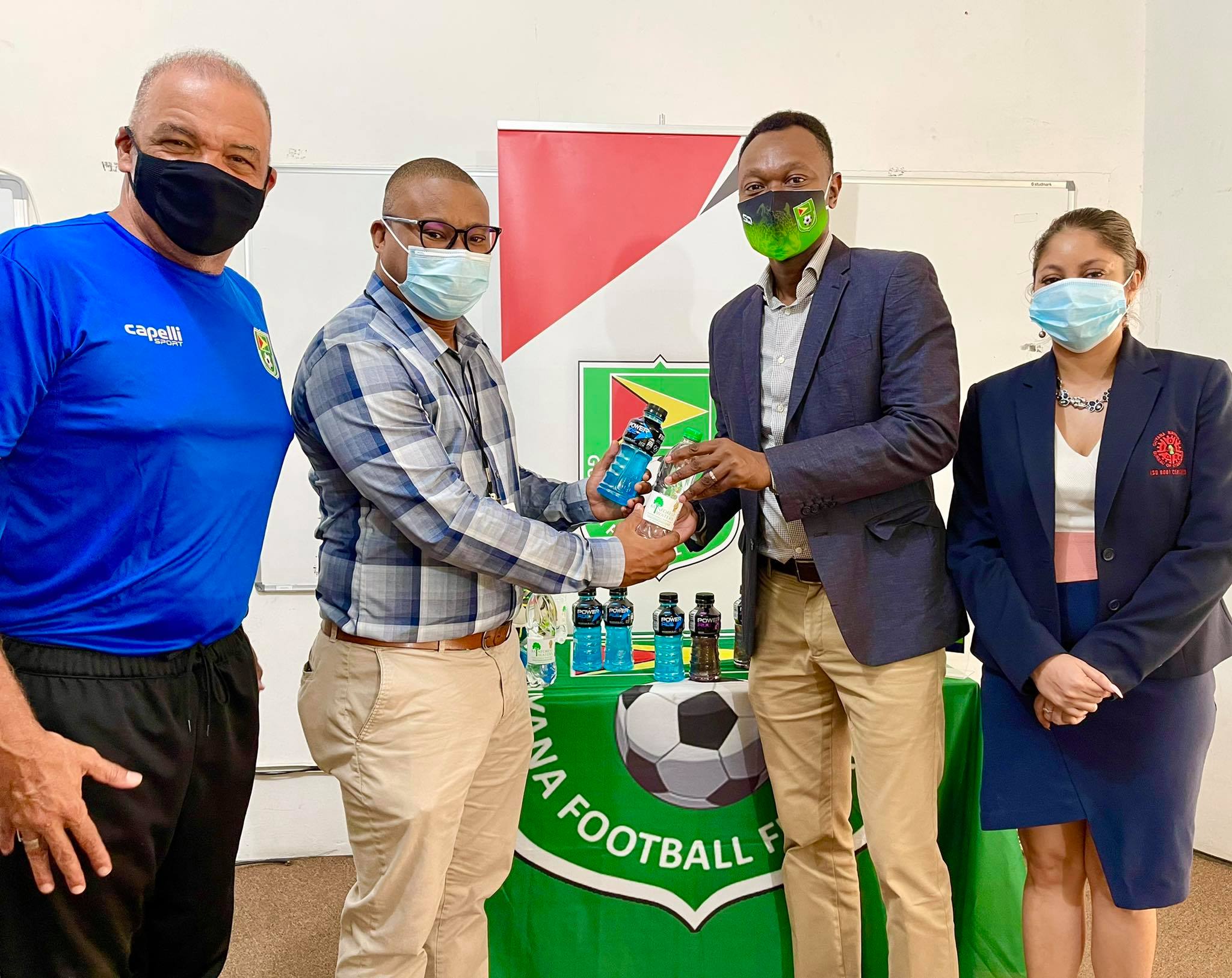 Banks DIH Brand Manager Colin King (second from left) hands over bottles of Powerade and Rainforest Waters to GFF’s Dion Innis, (third from left). Also in photo, head coach Marcio Maximo (extreme left) and GFF’s Lisa Ahmad (fourth from left).